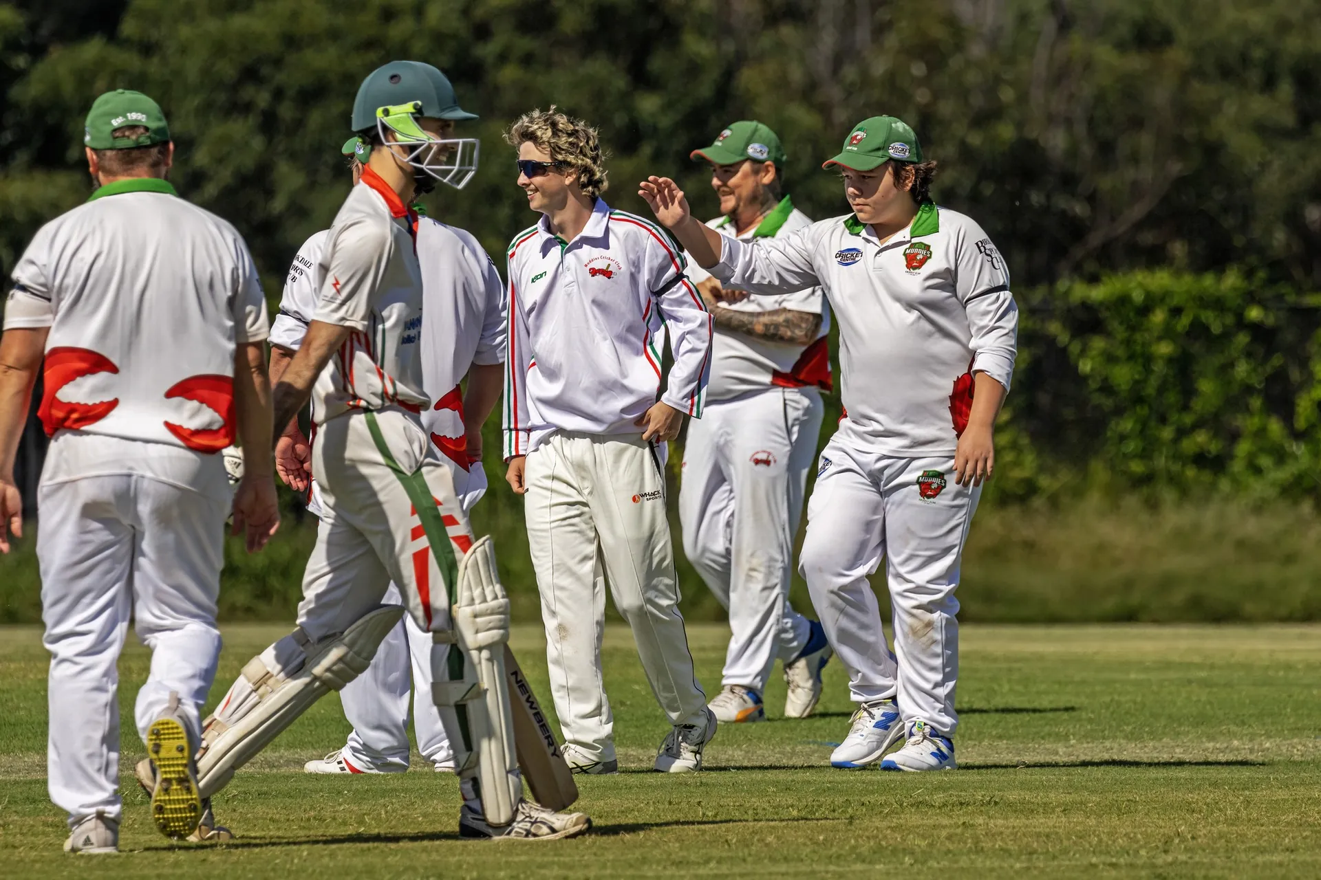 Muddies players walking off the field together after taking a wicket